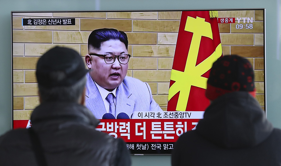 Il discorso di Kim Jong-un mostrato su una tv sudcoreana, mentre viene seguito a da alcuni passanti in una stazione ferroviaria di Seul (AP Photo/Lee Jin-man)
