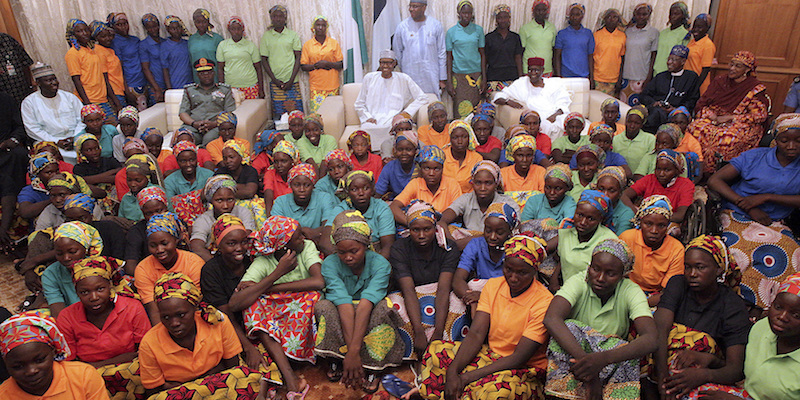 Il presidente della Nigeria Muhammadu Buhari e alcune delle ragazze di Chibok rapite da Boko Haram nel 2014, ad Abuja, il 7 maggio 2017 (Bayo Omoboriowo/Nigeria State House via AP)
