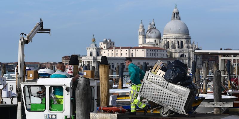 Un netturbino di Venezia mentre scarica in una barca della Veritas i rifiuti raccolti in città (MIGUEL MEDINA/AFP/Getty Images)