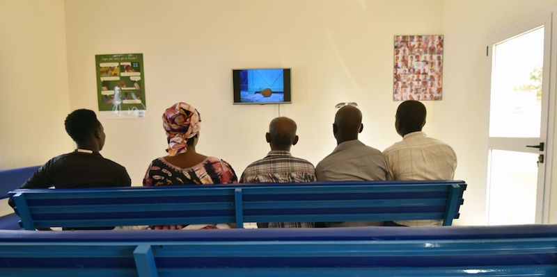 Cinque migranti guardano la tv nel centro dell'UNHCR a Niamey, in Niger (SIA KAMBOU/AFP/Getty Images)