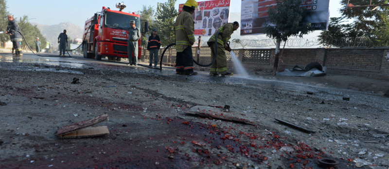 Pompieri e netturbini ripuliscono il luogo di un attentato suicida a Kabul, nel 2014. (SHAH MARAI/AFP/Getty Images)