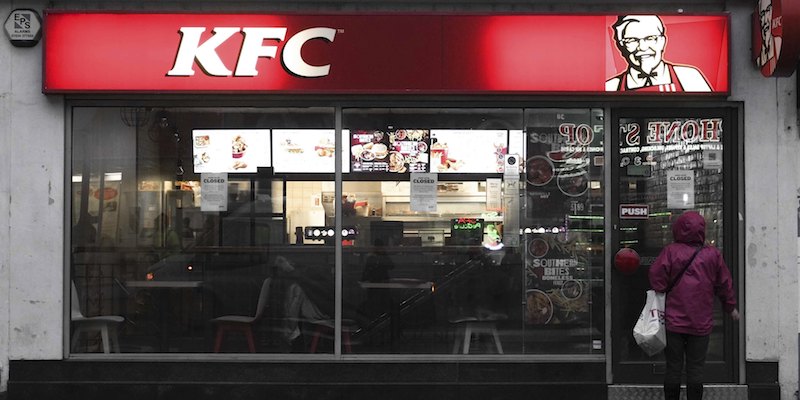 Un ristorante KFC di Londra e una donna che legge l'avviso sulla chiusura straordinaria dovuta alle mancate consegne di carne di pollo, il 19 febbraio 2018 (Claire Doherty/Sipa USA)(Sipa via AP Images)