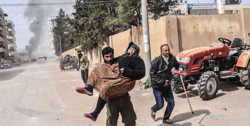 Un ribelle siriano porta in braccio una donna per allontanarla dalle esplosioni ad Afrin, Siria, 18 marzo 2018
(BULENT KILIC/AFP/Getty Images)