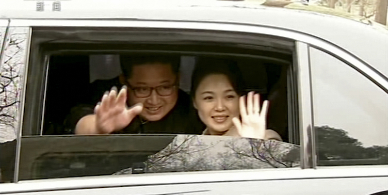 Il leader nordcoreano Kim Jong-un con la moglie Ri Sol-ju salutano da un'auto a Pechino, 27 amarzo 2018
(CCTV via AP Video)