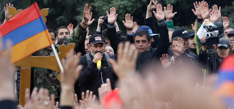 Nikol Pashinian, sullo sfondo, durante una manifestazione. (AP Photo/Sergei Grits)