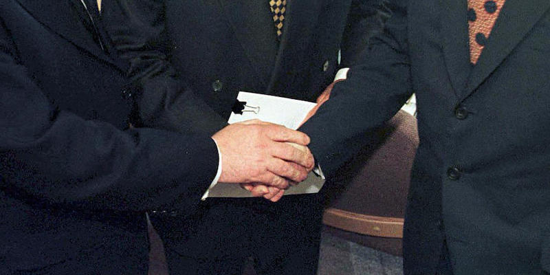 La stretta di mano tra il primo ministro britannico Tony Blair, il mediatore George Mitchell e il primo ministro irlandese Bertie Ahern dopo aver firmato l'Accordo del Venerdì Santo, 10 aprile 1998
(DAN CHUNG/AFP/Getty Images)