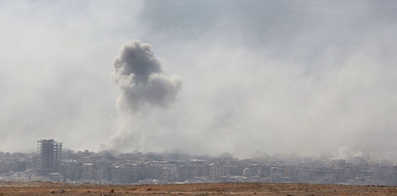 Una colonna di fumo a Douma, in Siria. Douma è una delle ultime aree controllate dai ribelli siriani e da diversi mesi è sotto pesanti attacchi delle forze alleate al regime di Assad (STRINGER/AFP/Getty Images)