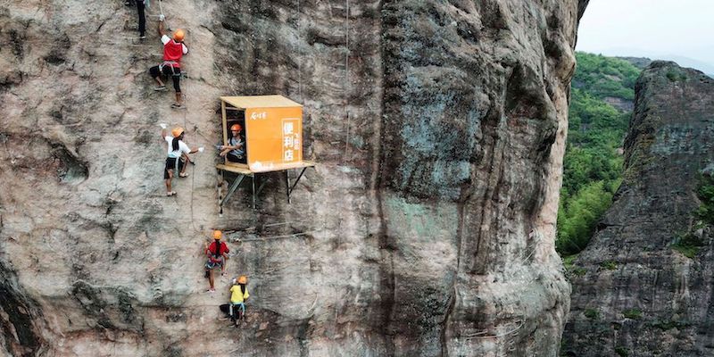 Persone durante un'arrampicata vicino a un chiosco a 100 metri d'altezza che vende cibo e acqua per gli scalatori, nella provincia dell'Hunan, 25 aprile 2018
(/AFP/Getty Images)