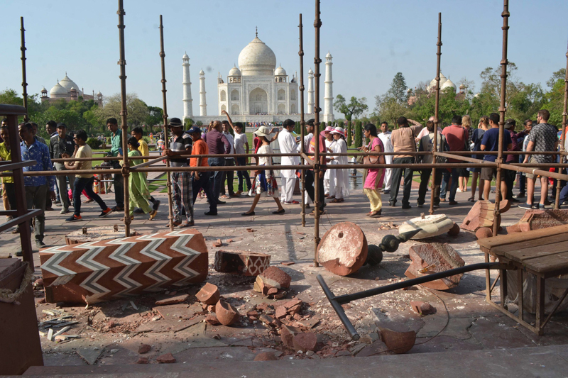 Persone davanti ai pezzi del pilastro caduto dall'Ingresso Reale del Taj Mahal. (AFP/Getty Images)