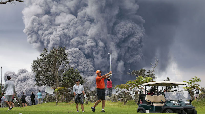 Le persone guardano il fumo causato dall'eruzione del vulcano Kilauea da un campo da golf, alle Hawaii, 15 maggio 2018
(Mario Tama/Getty Images)