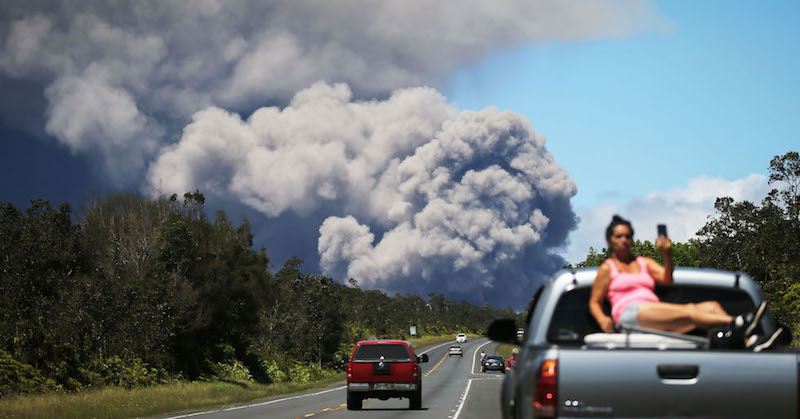 Le persone guardano il fumo causato dall'eruzione del vulcano Kilauea alle Hawaii, 15 maggio 2018

(Mario Tama/Getty Images)