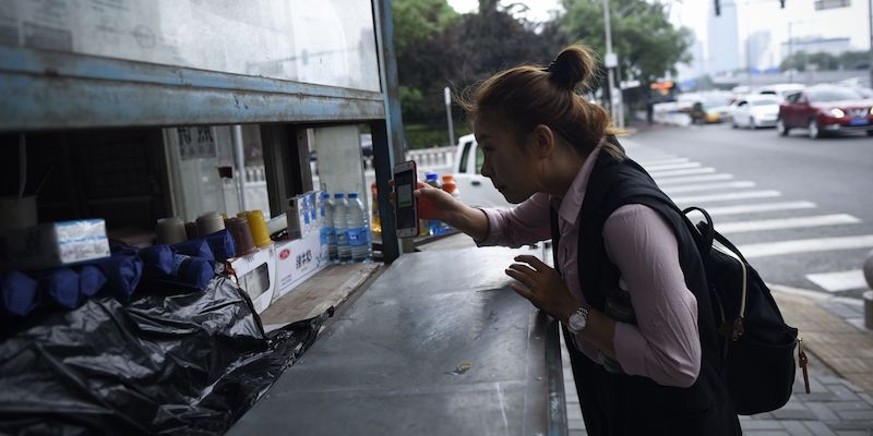 Una donna fa un pagamento a un chiosco usando WeChat, il 23 giugno 2017 (WANG ZHAO/AFP/Getty Images)