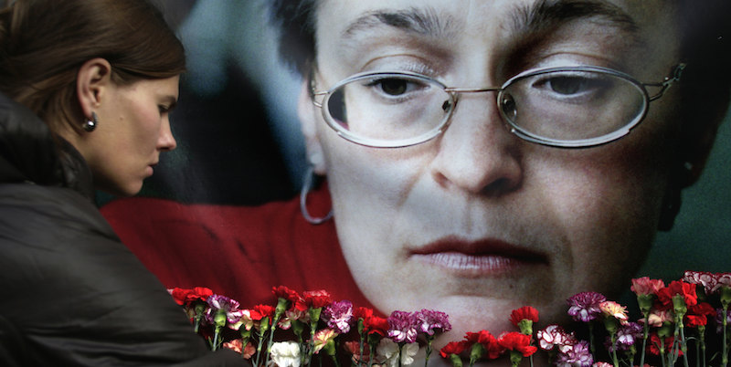 Una donna posa dei fiori vicino a un'immagine della giornalista russa Anna Politkovskaya, a Mosca (AP Photo/Pavel Golovkin, File)