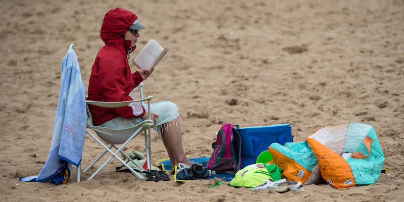 Una donna legge su una spiaggia inglese, il 26 luglio 2017 (Carl Court/Getty Images)
