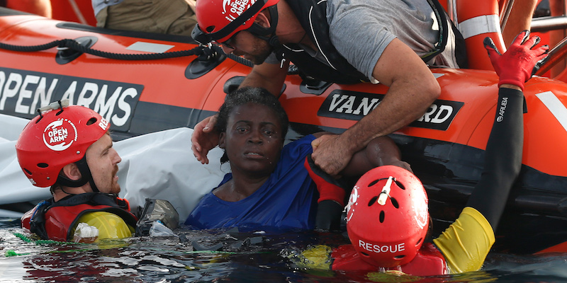 Tre soccorritori di Open Arms tirano fuori dall'acqua l'unica sopravvissuta al naufragio (PAU BARRENA/AFP/Getty Images)