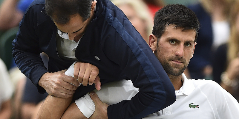 Novak Djokovic assistito da un preparatore durante l'ultima edizione di Wimbledon (GLYN KIRK/AFP/Getty Images)