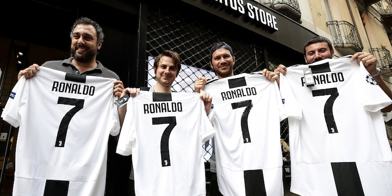 Tifosi della Juventus all'esterno dello store ufficiale della squadra a Torino con la maglia di Cristiano Ronaldo (ISABELLA BONOTTO/AFP/Getty Images)