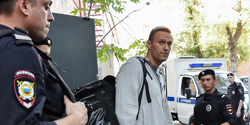 Alexei Navalny con alcuni poliziotti verso l'aula del tribunale di Mosca che poi lo ha condannato a 30 giorni di carcere, 27 agosto 2018
(VASILY MAXIMOV/AFP/Getty Images)