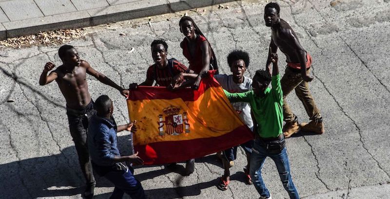 Migranti con una bandiera spagnola prima di entrare in un centro di accoglienza temporaneo a Ceuta, in Spagna, 22 agosto 2018
(JOAQUIN SANCHEZ/AFP/Getty Images)