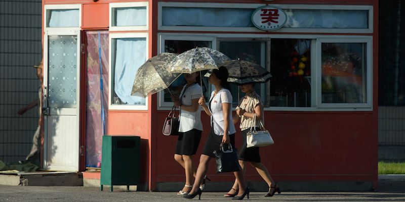 Un gruppo di donne con dei parasole su una strada di Pyongyang, in Corea del Nord, il 24 luglio 2018 (ED JONES/AFP/Getty Images)
