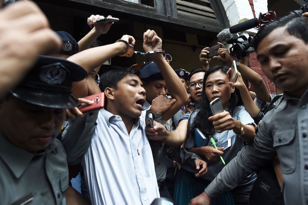 Il giornalista di Reuters Kyaw Soe Oo viene scortato all'esterno del tribunale di Yangon, Myanmar, dopo la sentenza e la condanna a 7 anni di carcere (YE AUNG THU/AFP/Getty Images)