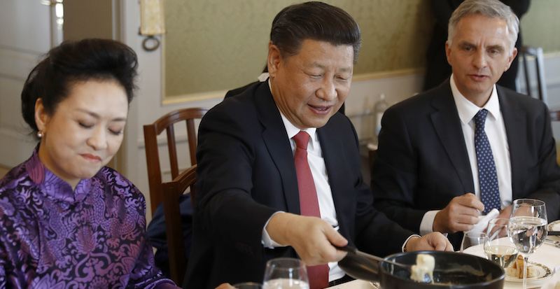 Il presidente cinese Xi Jinping, a tavola con la moglie Peng Liyuan e il ministro degli Esteri Didier Burkhalter, assaggia una fonduta di formaggio svizzero a una cena di stato a Berna, nel gennaio 2017
(PETER KLAUNZER/AFP/Getty Images)