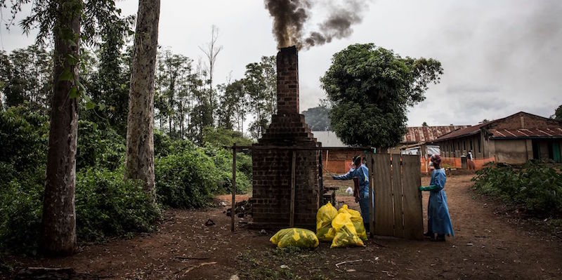 Operatori sanitari bruciano il materiale usato durante il trattamento di alcune persone contagiate dal virus ebola a Mangina, vicino a Beni, nella provincia del Kivu, Nord, il 21 agosto 2018 (JOHN WESSELS/AFP/Getty Images)
