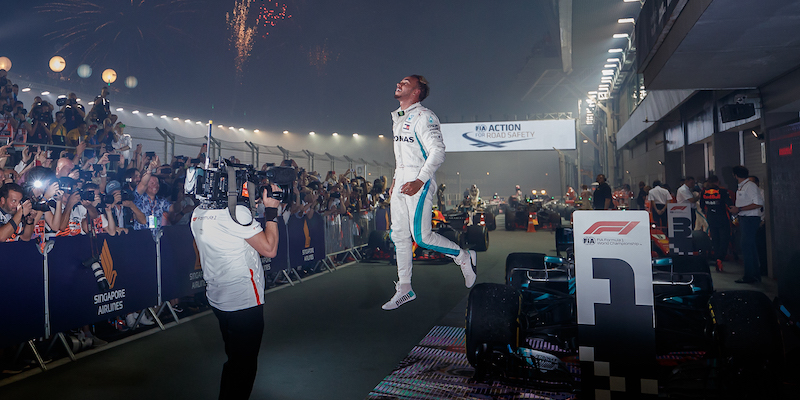 Lewis Hamilton salta giù dalla Mercedes dopo la vittoria nel Gran Premio di Singapore di Formula 1 (Lars Baron/Getty Images)