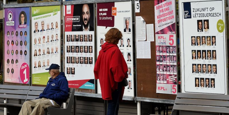 Una donna guarda i manifesti elettorali alla vigilia del voto per le comunali in Lussemburgo. (JOHN THYS/AFP/Getty Images)