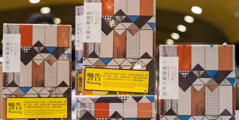 Copie di L'assassinio del commendatore, l'ultimo romanzo di Haruki Murakami, nella vetrina di una libreria di Hong Kong, accompagnate da note che avvisano che l'opera è stata giudicata "indecente" dai censori cinesi, 26 luglio 2018
(ANTHONY WALLACE/AFP/Getty Images)