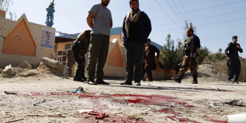 Soldati e poliziotti afghani sulla scena di un attentato suicida di fronte a un seggio elettorale di Kabul, il 20 ottobre 2018 (ANSA/ EPA/JAWAD JALALI)