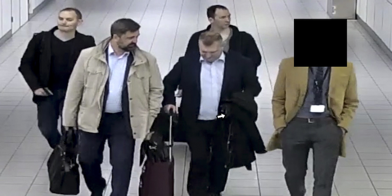 Un'immagine dei quattro uomini che le autorità olandesi hanno identificato come agenti dell'intelligence militare russa, mentre vengono accompagnati al loro aereo dopo essere stati scoperti il 13 aprile scorso (Dutch Defense Ministry via AP)