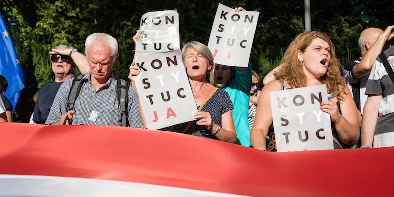 Cittadini polacchi protestano contro la riforma giudiziaria del governo, entrata in vigore lo scorso luglio, di fronte al palazzo del Senato a Varsavia. (WOJTEK RADWANSKI/AFP/Getty Images)