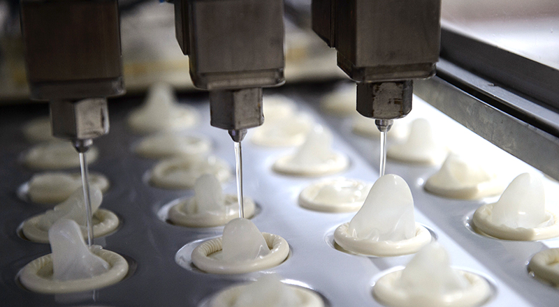 Lubrificazione dei preservativi durante la loro produzione industriale (YASUYOSHI CHIBA/AFP/Getty Images)