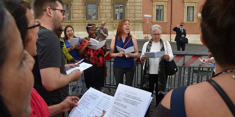 Un gruppo di uomini e donne della Women's Ordination Conference (WOC), durante la protesta per chiedere una maggiore rappresentazione delle donne nella Chiesa davanti a una delle porte del Vaticano, a Roma, il 3 ottobre 2018 (ANDREAS SOLARO/AFP/Getty Images)