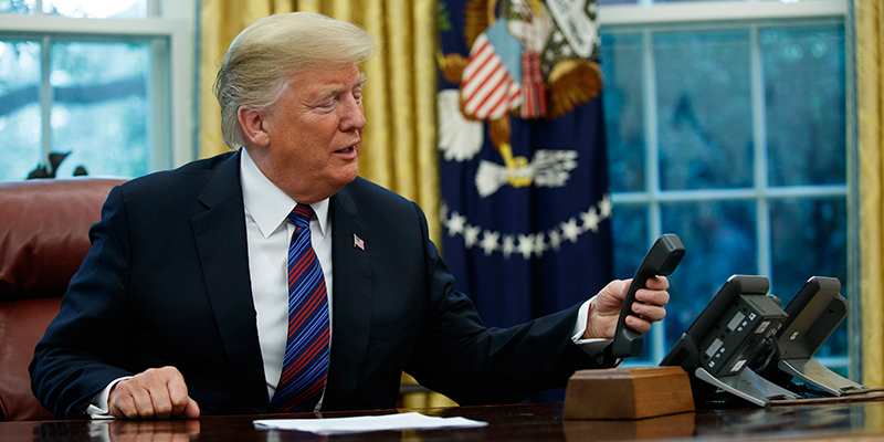 Il presidente degli Stati Uniti, Donald Trump, mentre prova a fare una telefonata nello Studio Ovale della Casa Bianca - Washington, DC, Stati Uniti (AP Photo/Evan Vucci)