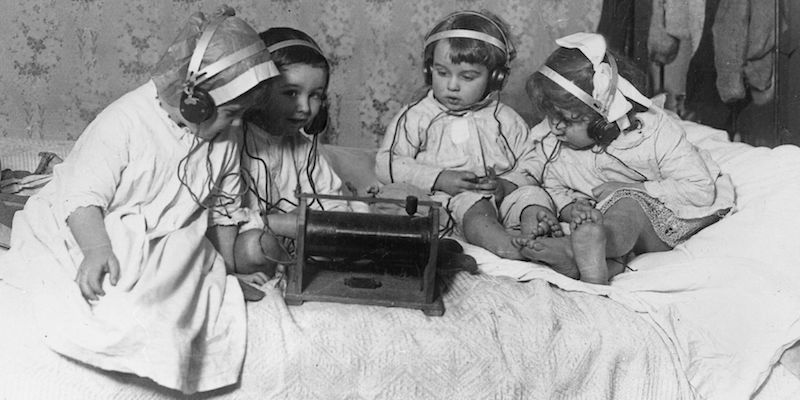 Quattro bambini ascoltano la radio con le cuffie, negli anni Trenta (Spencer Arnold/Getty Images)