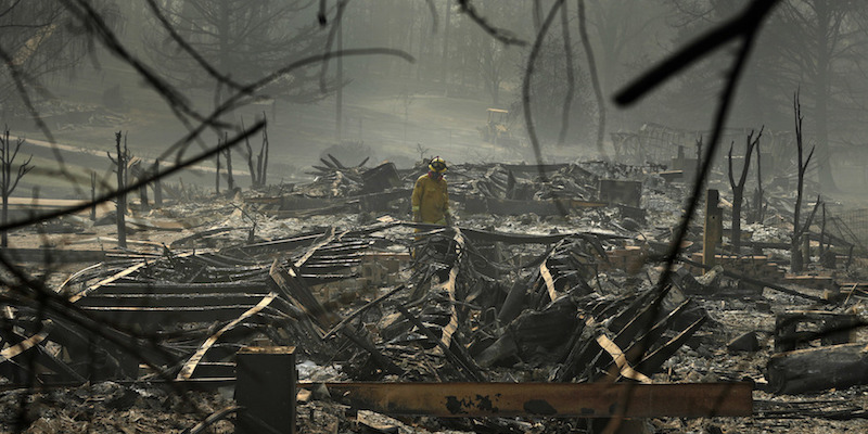 Un vigile del fuoco tra i resti di un trailer park di Paradise distrutto dal Camp Fire, il 16 novembre 2018 (AP Photo/John Locher)