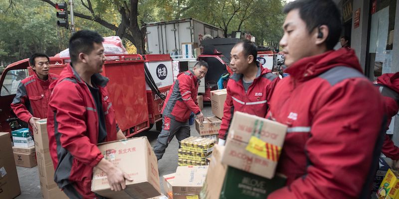 Un gruppo di lavoratori trasporta pacchi da consegnare a Pechino per il Singles' Day, il 6 novembre 2018 (FRED DUFOUR/AFP/Getty Images)