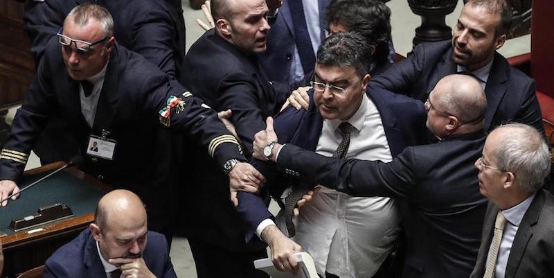 Emanuele Fiano del Pd viene trattenuto dagli assistenti parlamentari mentre cerca di avvicinarsi ai banchi della presidenza della Camera, 28 dicembre 2018 
(ANSA/GIUSEPPE LAMI)