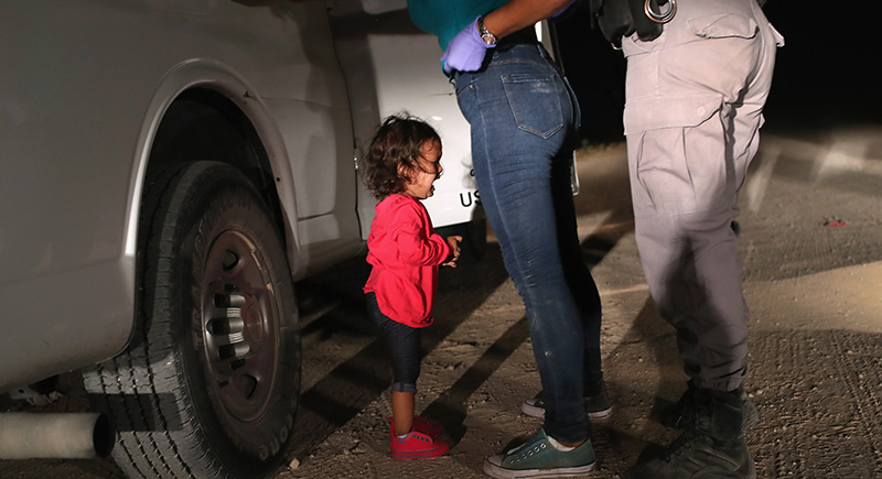 Un bambino di due anni durante l'arresto e la perquisizione di sua madre, richiedente asilo dell'Honduras, al confine tra Texas e Messico, 12 giugno 2018 (John Moore/Getty Images)