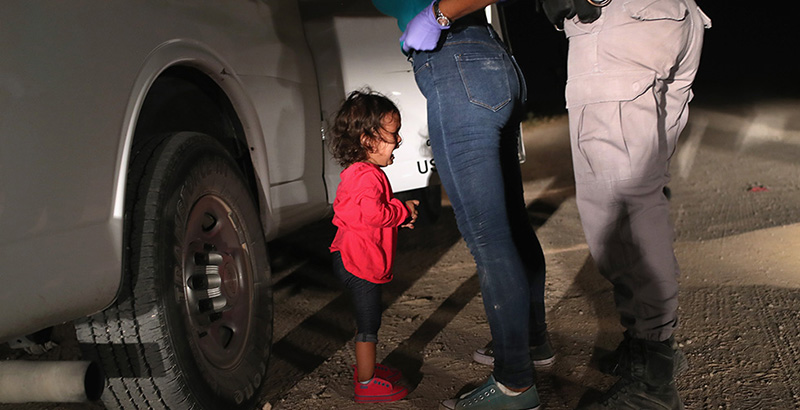 Una bambina di due anni piange mentre sua madre viene perquisita vicino al confine tra Messico e Stati Uniti, il 12 giugno 2018: madre e bambina sono arrivate dall'Honduras per chiedere asilo negli Stati Uniti (John Moore/Getty Images)