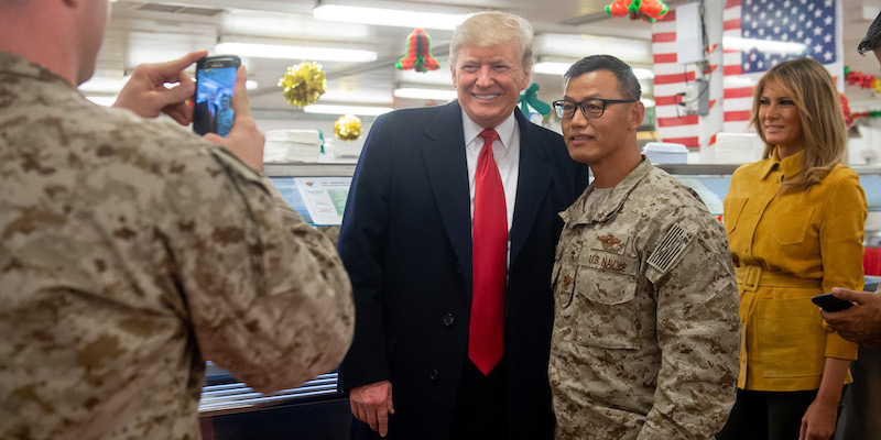 Il presidente statunitense Donald Trump si fa fare una foto con il tenente comandante Kyu Lee, cappellano militare di una squadra di Navy Seals alla base militare al Asad in Iraq, 26 dicembre 2018 (SAUL LOEB/AFP/Getty Images)