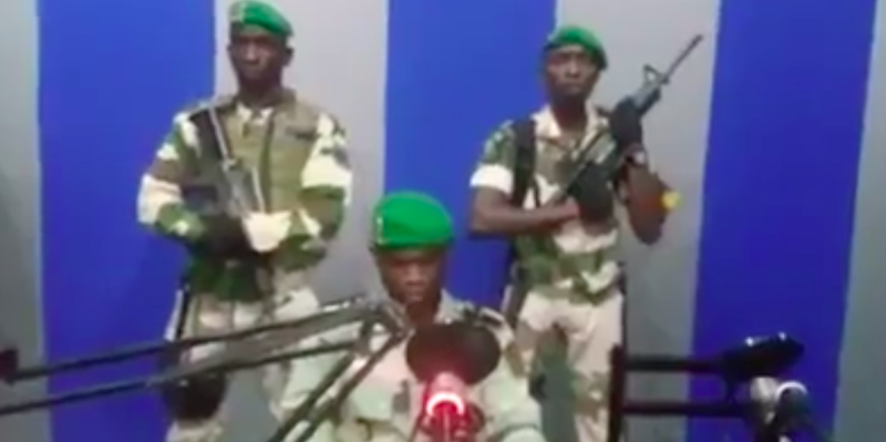 Il tenente Kelly Ondo Obiang legge un messaggio in radio, accompagnato da altri due soldati armati. Libreville, Gabon, 7 gennaio 2019