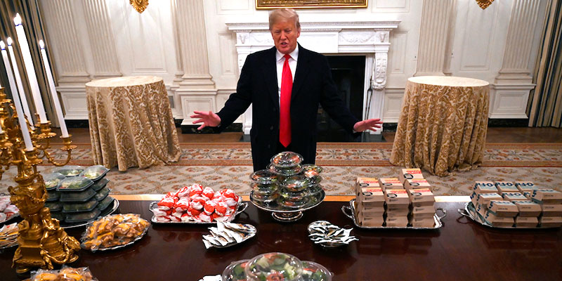 Il presidente degli Stati Uniti, Donald Trump, davanti al banchetto a base di fast food 