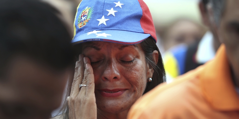 Una donna venezuelana che indossa un cappellino con la bandiera del proprio paese piange durante una protesta contro il presidente Nicolás Maduro fuori dall'ambasciata del Venezuela a Lima, in Perù, il 10 gennaio 2019 (AP Photo/Martin Mejia)