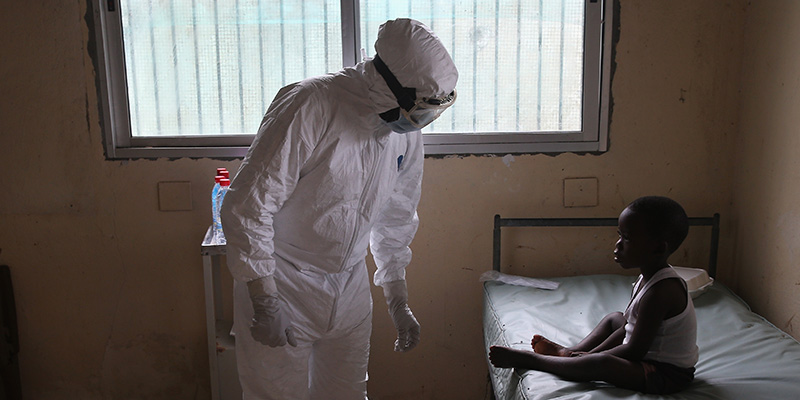Un operatore sanitario visita un bambino durante un’epidemia di Ebola a Monrovia, Liberia, nel 2014 (John Moore/Getty Images)