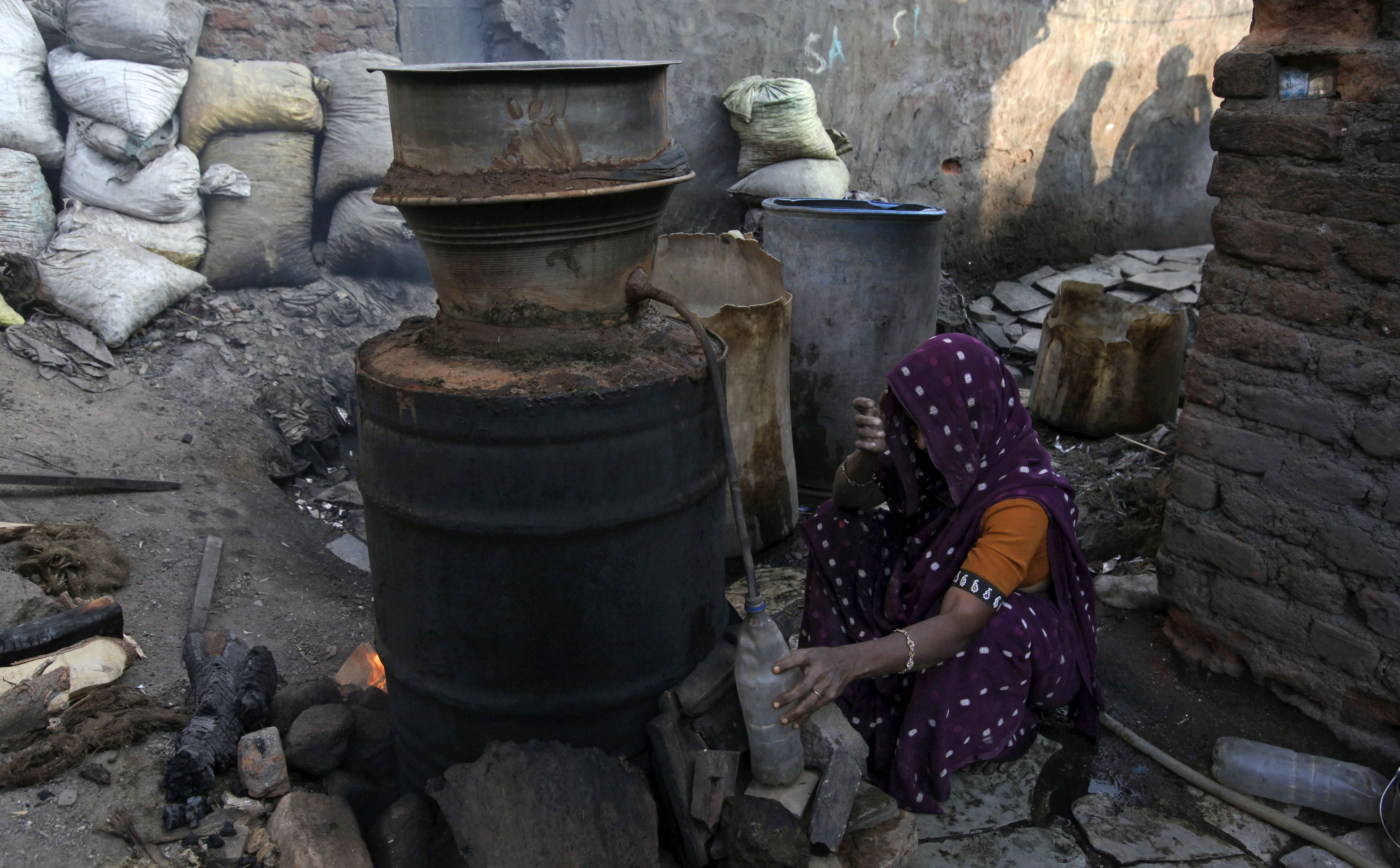 Una donna prepara liquore artigianale nello stato di Andhra Pradesh. (AP Photo/Mahesh Kumar A.)