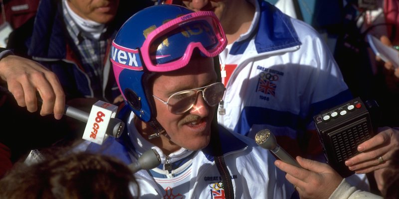 Eddie "the Eagle" Edwards in mezzo a un gruppo di giornalisti il 23 febbraio 1988, alle Olimpiadi di Calgary (Getty Images)