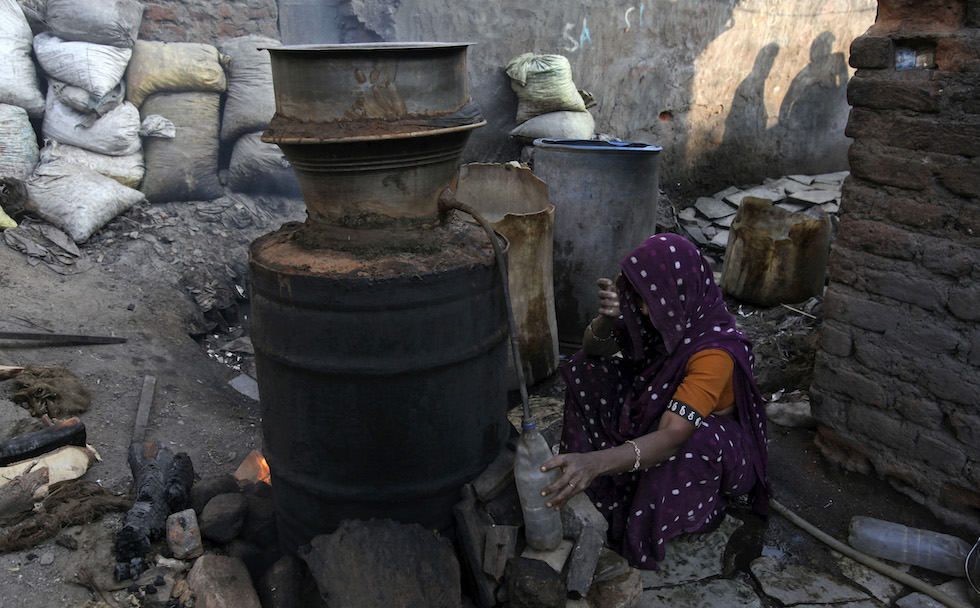 Una donna indiana prepara un liquore artigianale (AP Photo/Mahesh Kumar A.)
